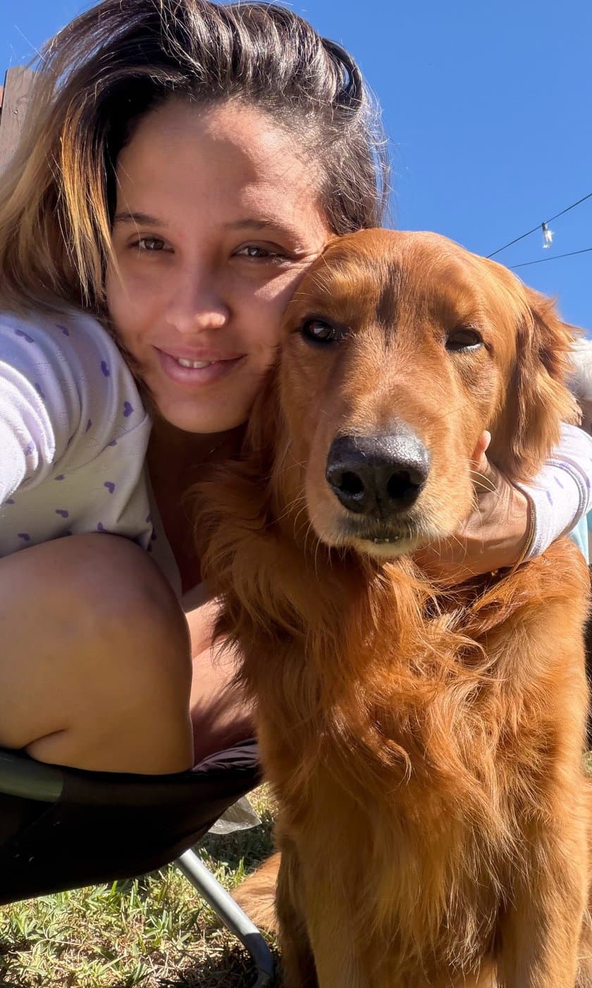 Jessica abrazando a un golden en el patio